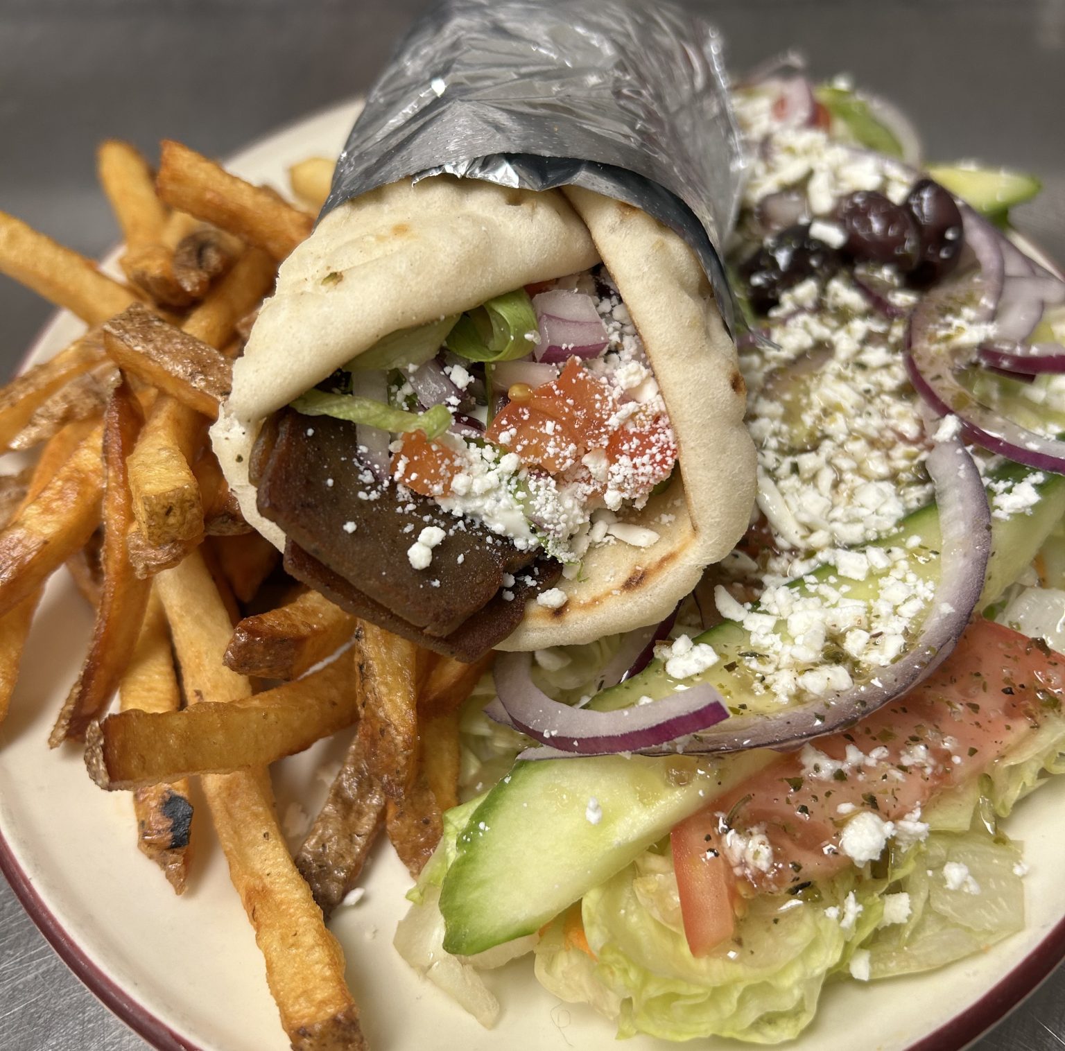 Fireside Welland restaurant gyro dinner with gyro meat in a pita fresh cut fries and Greek salad